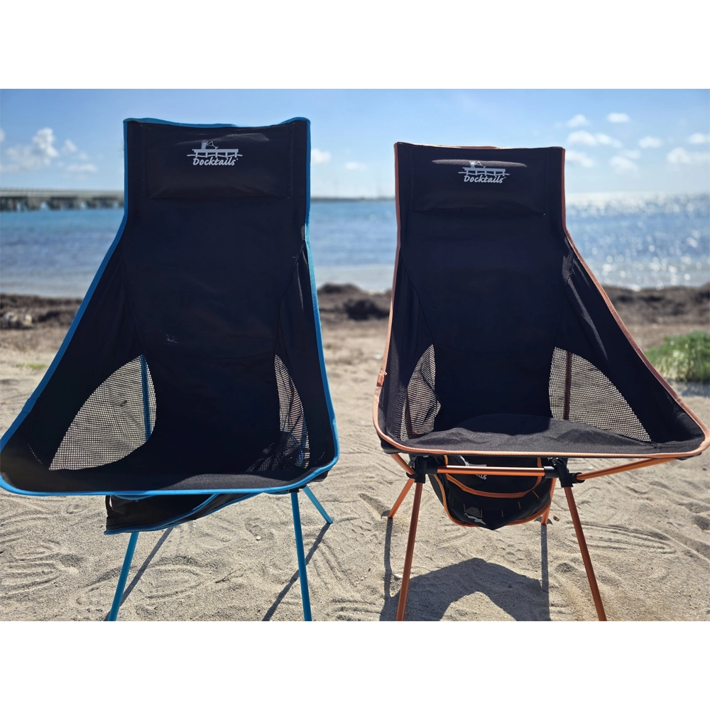 Two portable chairs on a sandy beach with water and sky in the background