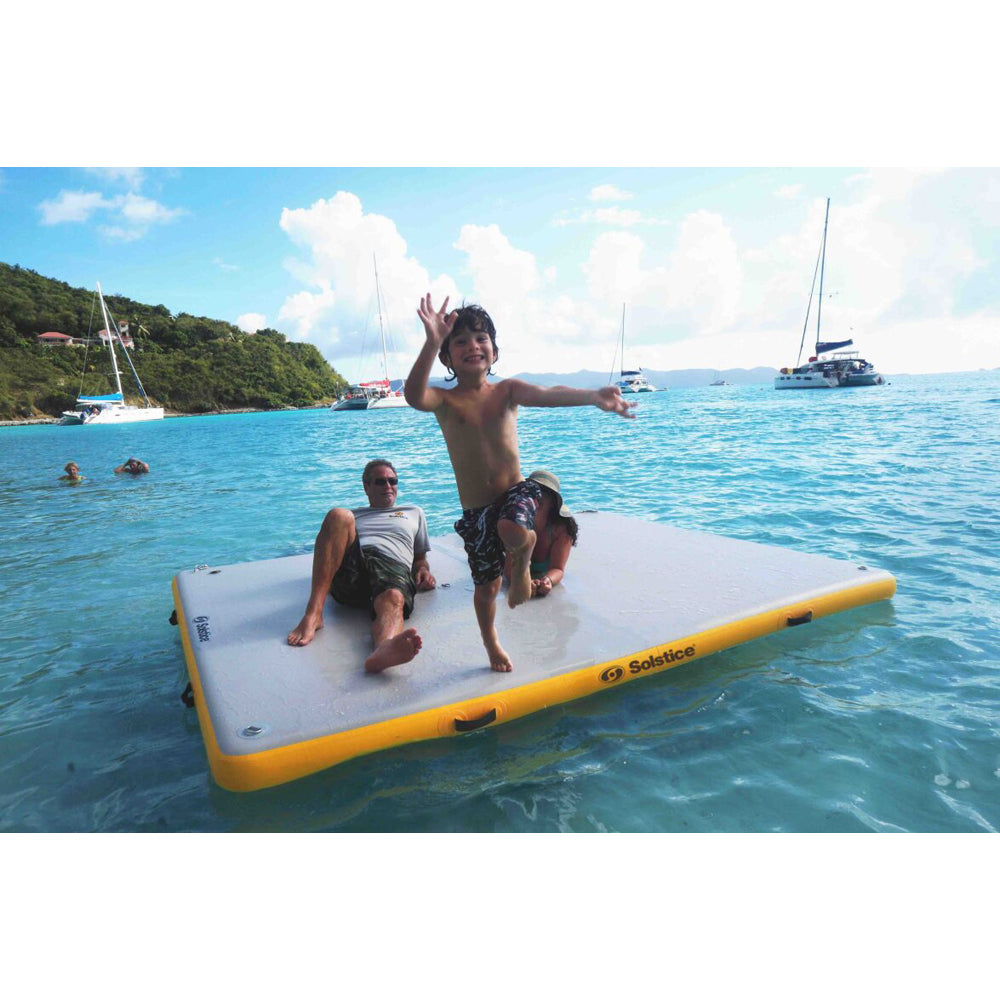 Solstice inflatable dock in the ocean with a child jumping off the dock