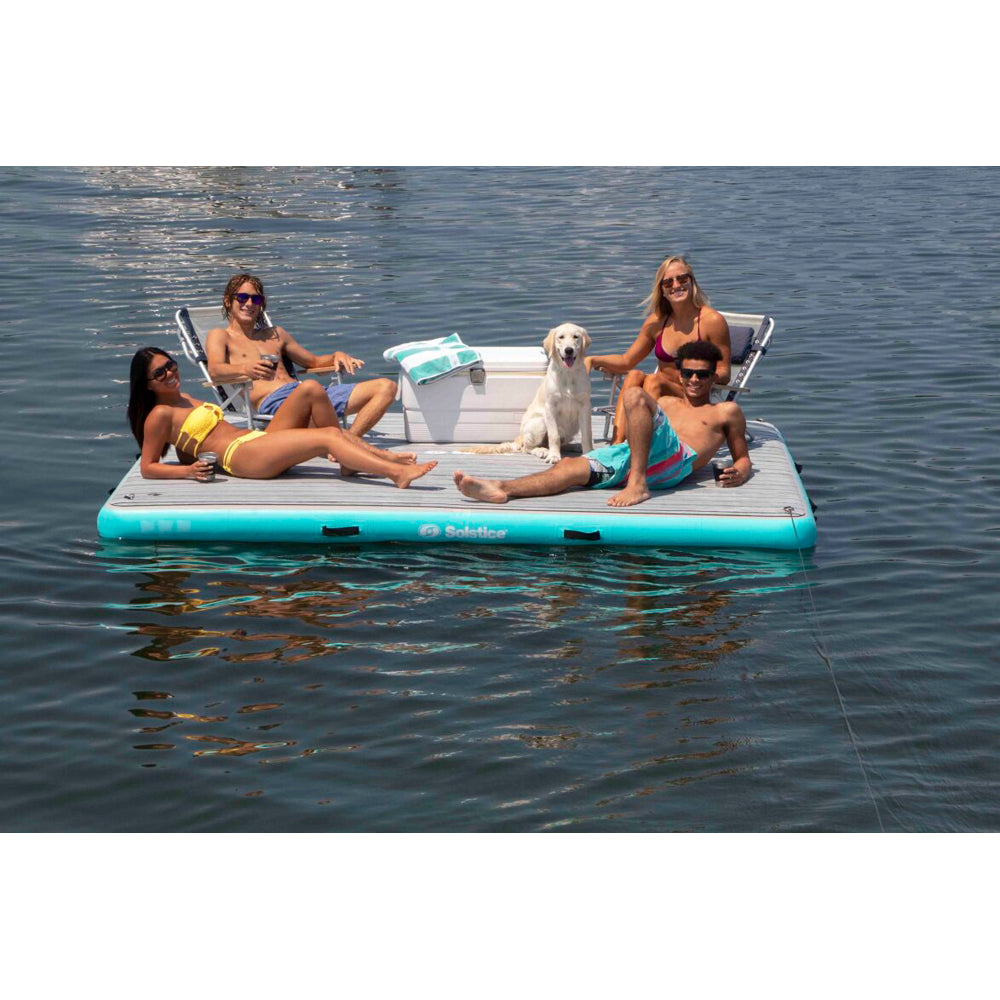 Solstice inflatable dock with integrated traction pad, shown holding four people, a dog, beach chairs and a cooler
