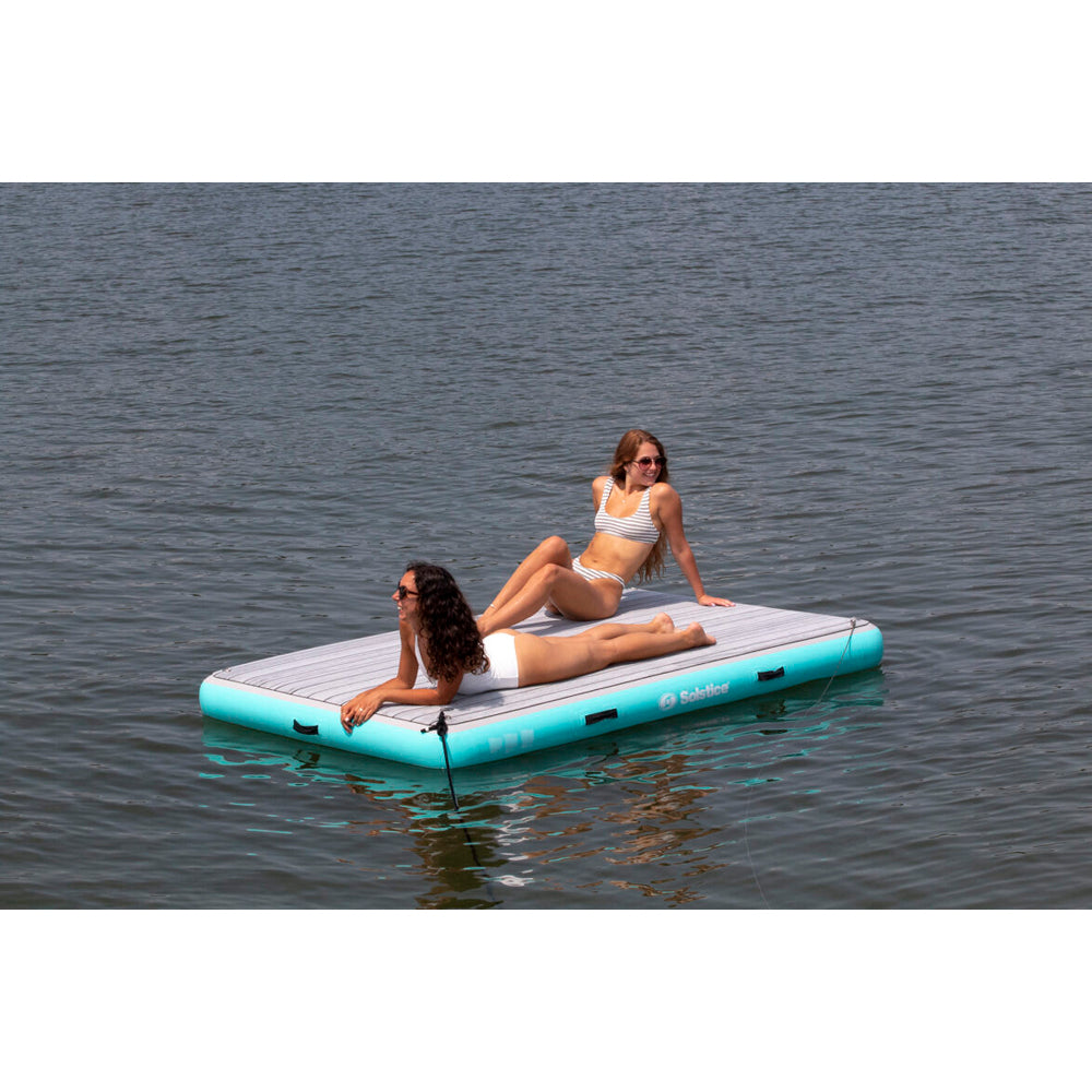 Solstice luxury inflatable dock with integrated traction pad, shown with two people on the dock