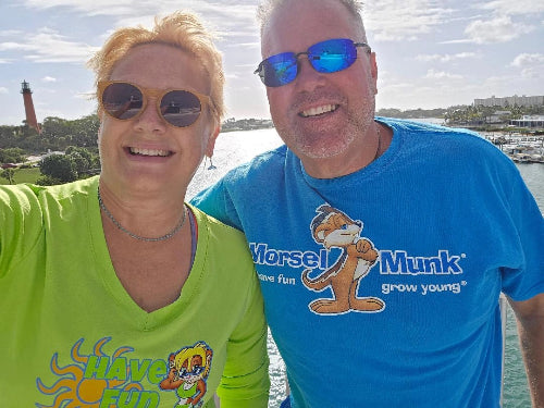 Woman and man with a waterbody and lighthouse in the background