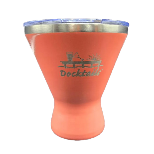 A coral insulated tumbler with a stainless steel rim and a clear lid, featuring a laser-engraved 'Docktails' logo with a cocktail glass and sun graphic on the front.